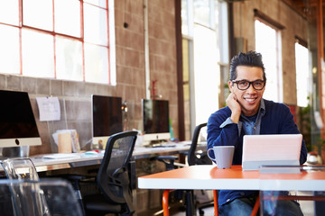 Designer Sitting At Meeting Table Working On Digital Tablet