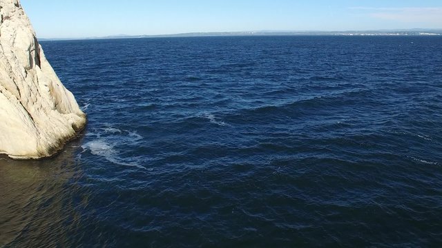Vol pr&egrave;s d'un rocher &agrave; ras de l'eau vue par un drone