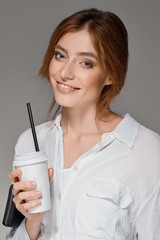cute red hair girl drinks through straw from the glass