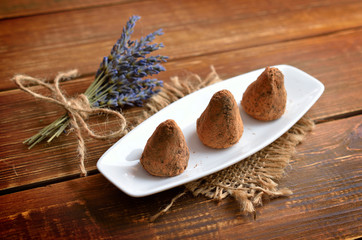 Vegan Homemade Candies in cocoa powder with lavander  bouquet.