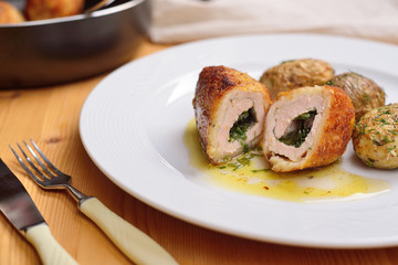 Chicken Kiev with potatoes and dill on a white plate