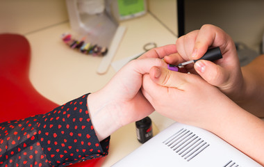 Manicurist Applying Clear Coat to Finger Nails