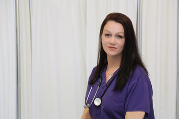 Portrait of young attractive female healthcare professional, nurse with white copy space
