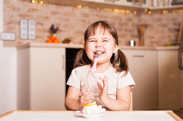 happy little girl with spoon and cake