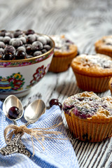 Obraz na płótnie Canvas Muffins, a Cup of blackcurrant and two silver spoons