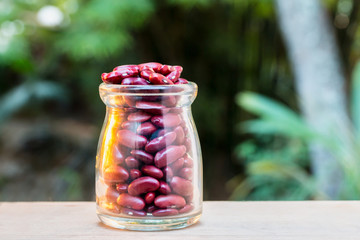 Red beans in a glass and on the wood floor