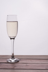 Champagne glass on wooden table against white background