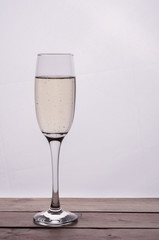 Champagne glass on wooden table against white background