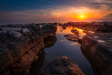 Beautiful Vibrant Sunset Over the Sea with Rocks in Foreground