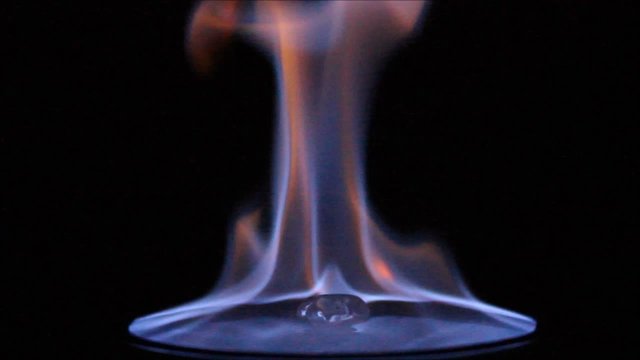Burning ice cube on a plate in the dark