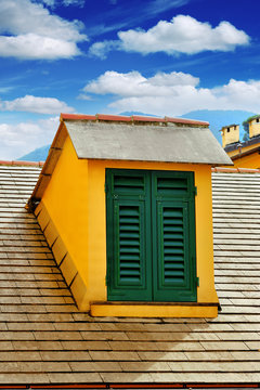 window with shutters on the roof on blue sky background