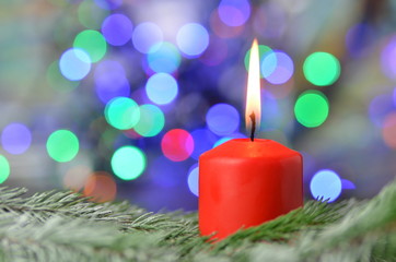 paląca się czerwona świeczka na tle magicznego bokeh