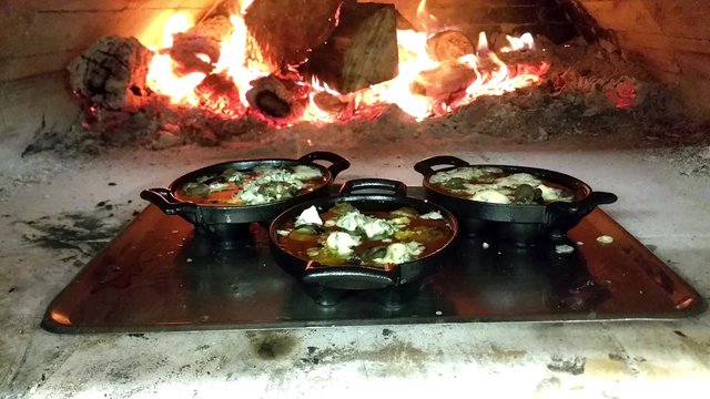 Frying snail escargots, in a wooden heated oven, at a restaurant kitchen