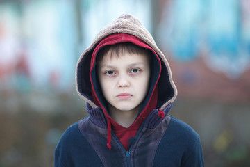 dramatic portrait of a little homeless boy