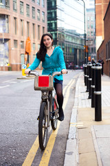 Obraz na płótnie Canvas young woman riding a hire bike