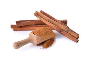 Cinnamon stick and powdered with spoon on white background