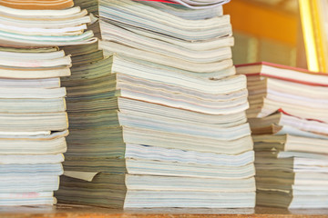 Many books pile on wooden table at library