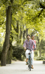 Fototapeta na wymiar Young couple riding on the bicycle
