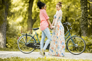 Fototapeta na wymiar Young women posing by the bicycle