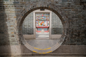 Round doorway at the Pak Tai Temple on Cheung Chau Island in Hong Kong, China, viewed from the...