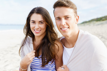 Romantic young couple sitting on the beach