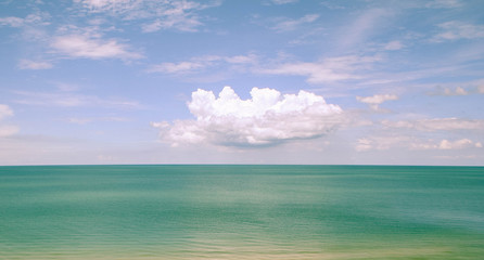 white cloud on blue sky and green sea