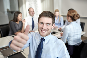 group of smiling businesspeople meeting in office