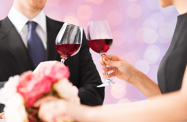 happy engaged with flowers clinking wine glasses
