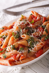 arrabbiata pasta with Parmesan cheese on a plate closeup. vertical
