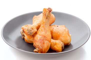 fried chicken thighs in dark porcelain dish