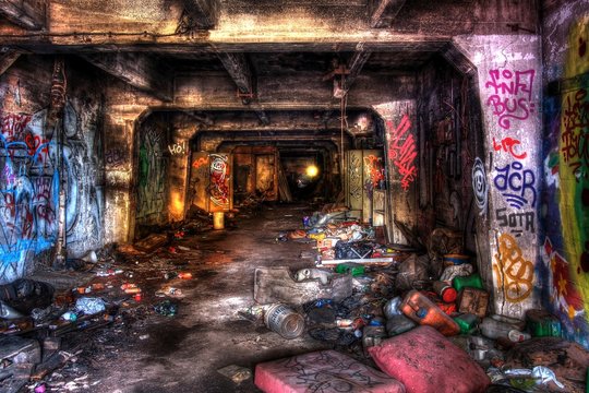 Underground scary tunnel covered with junk and graffiti