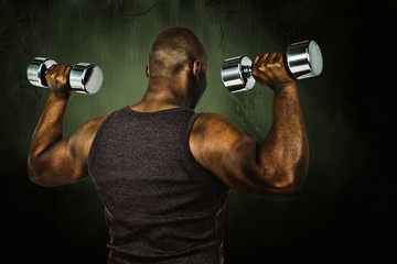 Naklejka na ściany i meble Composite image of fit man exercising with dumbbell 