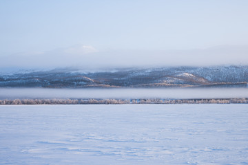 Morgennebel über einem zugefrorenen See in Schweden