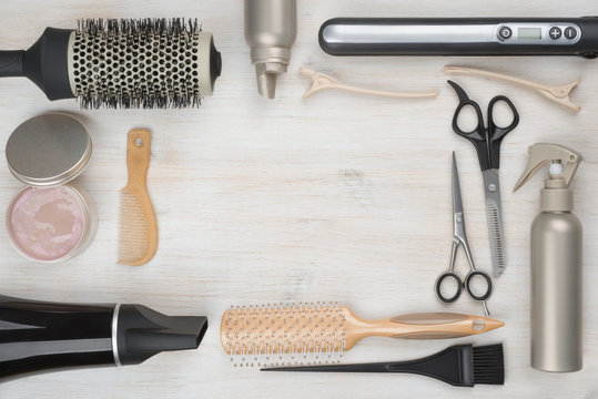Hairdressing tools on wooden background with copyspace in the middle