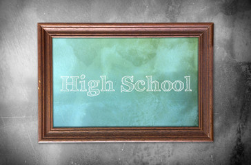Picture frame with word of "High school" cement wall background