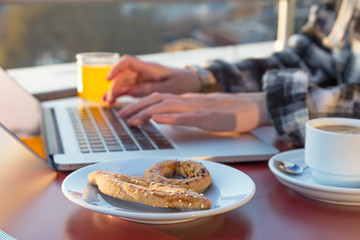 Freelancer Casual dressed woman Person at wooden desk working breakfast