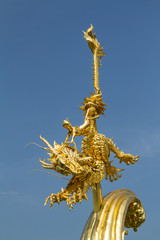 gold statue of thai tale kid and horse dragon