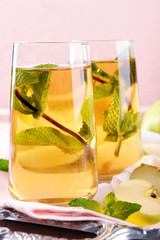 Glasses of apple juice with fruits and fresh mint on table close up