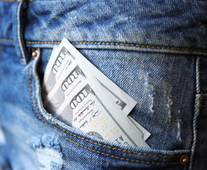 Dollar banknotes in jeans pocket closeup