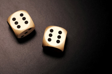 Two wooden dices on a black background.