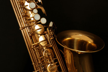 Beautiful golden saxophone on black background, close up