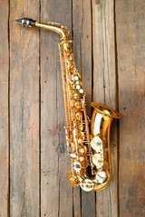 Beautiful golden saxophone on wooden background