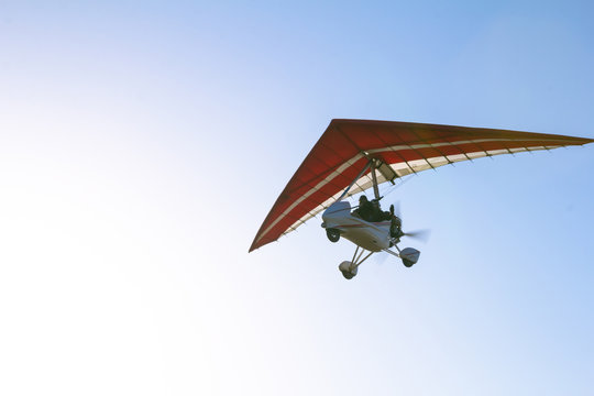 Motorized hang glider soaring in the blue sky