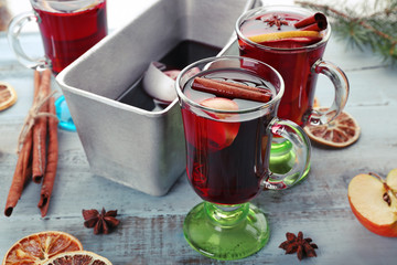 Tasty mulled wine and spices, on blue wooden background, close-up