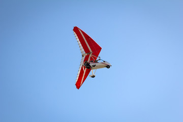 Motorized hang glider soaring in the blue sky