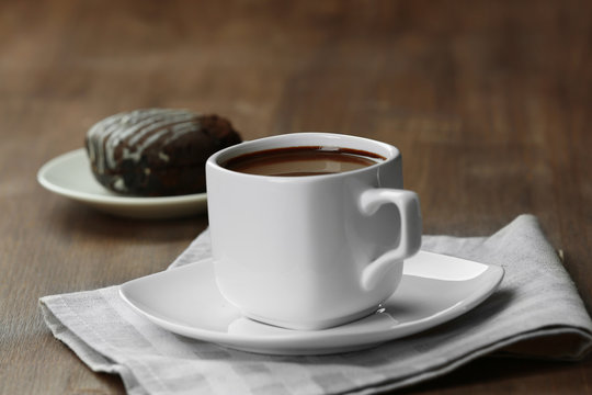 Cup of cacao with biscuit on wooden table