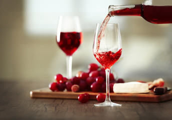 Pouring pink wine from bottle into the wineglass