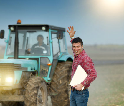 Happy farmer with tractor in field