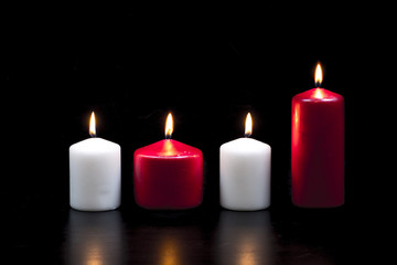 Obraz na płótnie Canvas White and red candles on black background
