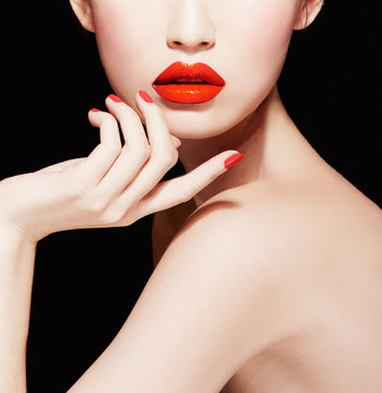 Beautiful skin woman with red lips and nails isolated on black background. Body care, Makeup.